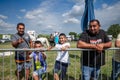 RUMA, SERBIA - JUNE 25, 2023: Portrait of a Roma family, two fathers and two kids from the romani community, happy, looking at the