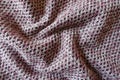 Rumpled pink, grey and white woolen fabric with diamonds pattern