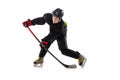 On the run. Child, hockey player with the stick on ice court and white background. Royalty Free Stock Photo