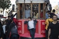 Runaway boarded passenger hanging behind historic red tram. Self-confident