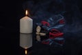 Rune Mannaz, burning candle, antique leather bag for Scandinavian runes on a dark background with a mirror image of the rune