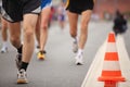 Runing man's legs near color cone on asphalt