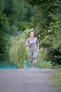 Runner athlete running on park trail. woman fitness jogging work Royalty Free Stock Photo