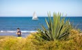 An Algarve beach with the ocean and a runner out of focus in the background.