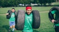 Runner carrying tires in a test of extreme obstacle race