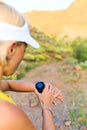 Runner checking sports watch in summer mountains on trail Royalty Free Stock Photo