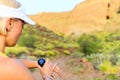 Runner checking sports watch in summer mountains on trail