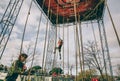 Runner climbing rope in a test of obstacle race