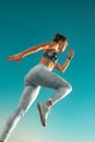 Runner concept. Jogging run. Strong athletic woman running on sky background wearing in the sportswear. Fitness and Royalty Free Stock Photo