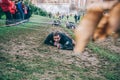 Runner crawling under barbed wire in a test of extreme obstacle race