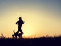 Runner and dog silhouttes in sunset light Royalty Free Stock Photo