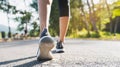 Runner feet running on road closeup on shoe. Woman fitness sunrise jog workout wellness concept. Young fitness woman runner athlet