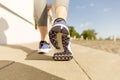 Runner feet running on road closeup on shoe. woman fitness sunrise jog workout welness concept