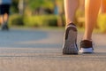 Runner feet running on the road in the outdoor workout park, closeup on shoe. Asian fitness woman running for healthy and relax Royalty Free Stock Photo