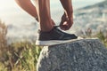 Runner, foot and tying laces on rock, outdoors and prepare for cardio and marathon training. Man, stone and shoe for Royalty Free Stock Photo