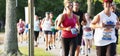 Runner gives two thumbs up during crwded trail 5K race in a park