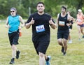 Runner gives two thumbs up suring 10K race on a grass field