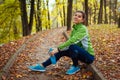 Runner having rest after workout in autumn park. Happy woman holding water bottle. Sportive active lifestyle Royalty Free Stock Photo