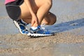 Runner hold her sports injured ankle during sports training on beach