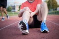 Runner with injured knee on track Royalty Free Stock Photo