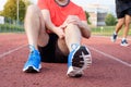 Runner with injured knee on track Royalty Free Stock Photo