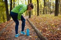 Runner injured leg during training in autumn park. Woman feels hip pain holding it with hand. Workout hurt Royalty Free Stock Photo