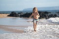 Runner kid boy have fun on tropical sea beach. Funny child run with splashes by water pool along surf edge. Kids Royalty Free Stock Photo