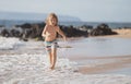 Runner kid boy have fun on tropical sea beach. Funny child run with splashes by water pool along surf edge. Kids Royalty Free Stock Photo
