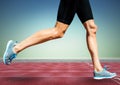 Runner legs on track against blue green background