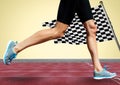 Runner legs on track against yellow background and checkered flag