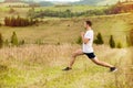 Runner man stretching legs before cross country trail run. Fit male runner exercise training outdoors in beautiful autumn mountain Royalty Free Stock Photo