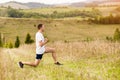 Runner man stretching legs before cross country trail run. Fit male runner exercise training outdoors Royalty Free Stock Photo