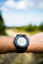 Runner on mountain trail looking at stopwatch, activity tracker Royalty Free Stock Photo