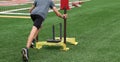 Runner pushing a sled with weights on a turf field at practice Royalty Free Stock Photo
