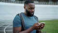 Runner reading good news on smartphone at track. man using mobile phone outdoors Royalty Free Stock Photo