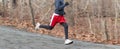 Runner running fast downhill in the woods with a blurred background