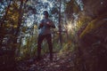 Runner is running through misty morning autumn forest during sunrise