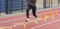 Runner running over six inch hurdles on a track