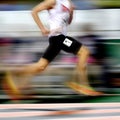 Runner Running a Race on Track with Baton Relay Team Score Motion Blur Royalty Free Stock Photo