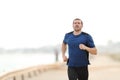 Runner is running towards camera training on the beach