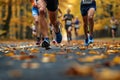 Runner\'s legs in front of a group of runners in a popular race running on an asphalt road with tree leaves on the fooor Royalty Free Stock Photo