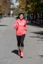 Runner sport woman in Autumn sportswear running and training on jogging outdoors workout in city park smiling happy Royalty Free Stock Photo