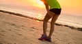 runner with sports injured leg running at sunset sandy beach