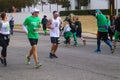 Runner in St Patricks Day Parade with woman excitedly waving at man running the other way who is waving back Tulsa Oklahoma USA 3