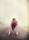 Runner, start and woman ready outdoor in forest, park or woods for exercise in winter. Morning, fog and person with