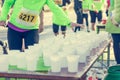 Runner taking a cup of water at H20 stand. Royalty Free Stock Photo