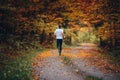 Runner trains in the picturesque autumn nature surrounded by colorful forest