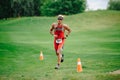 The runner after the transition to cycling. Triathlete man running in triathlon suit training for ironman race