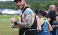 Runner turns and gives a thumbs up at camera during 10K race in park