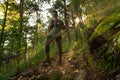 Runner wearing mask runs through autumn forest in the morning during sunrise